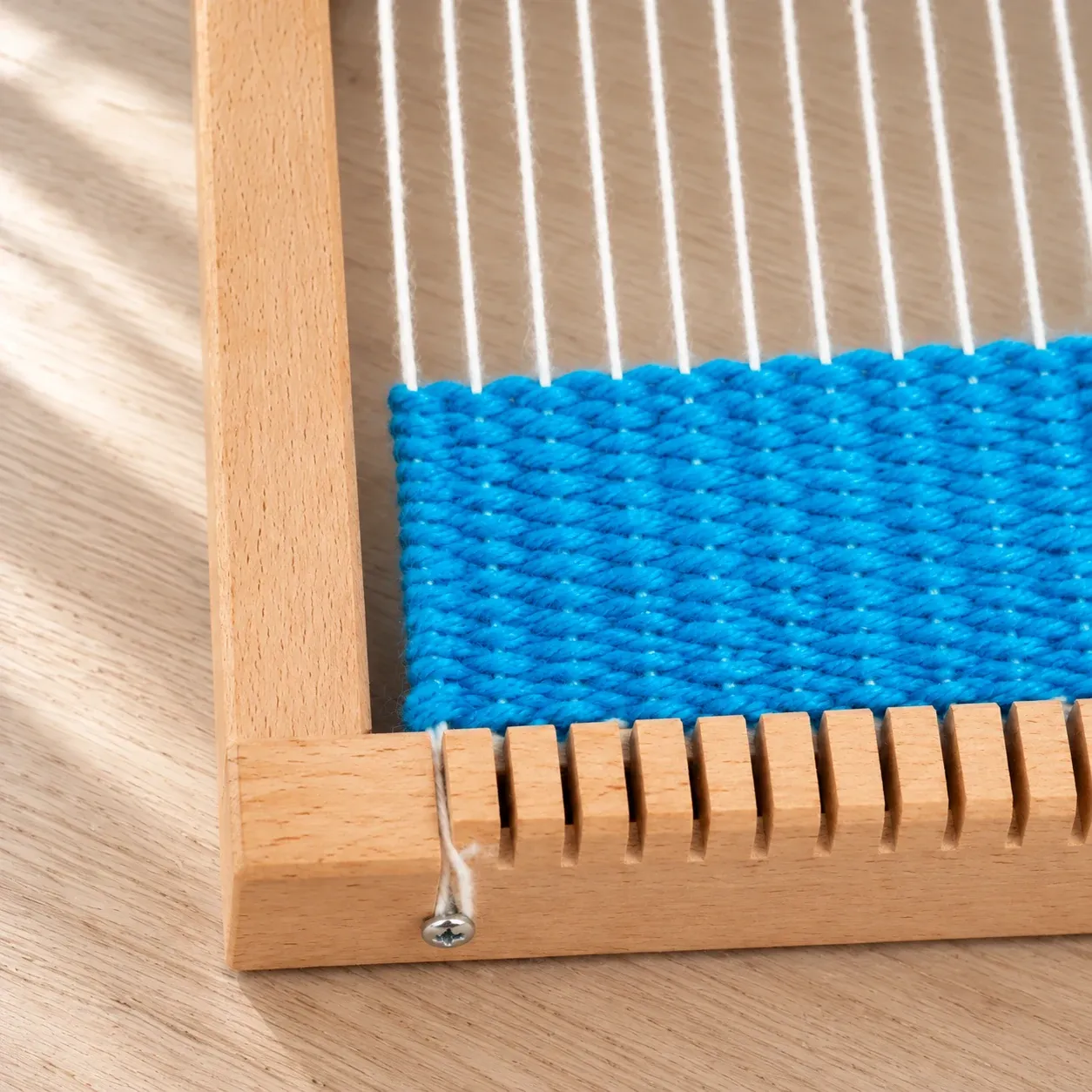 Close view of blue weaving and wooden frame