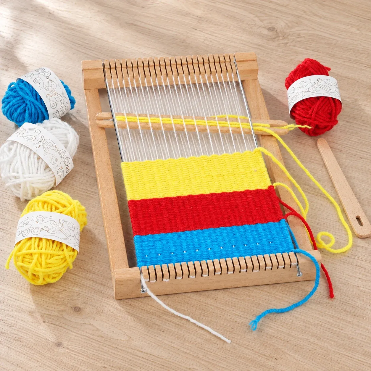 29 by 19 cm loom with four yarn colors; striped weaving shown as an example