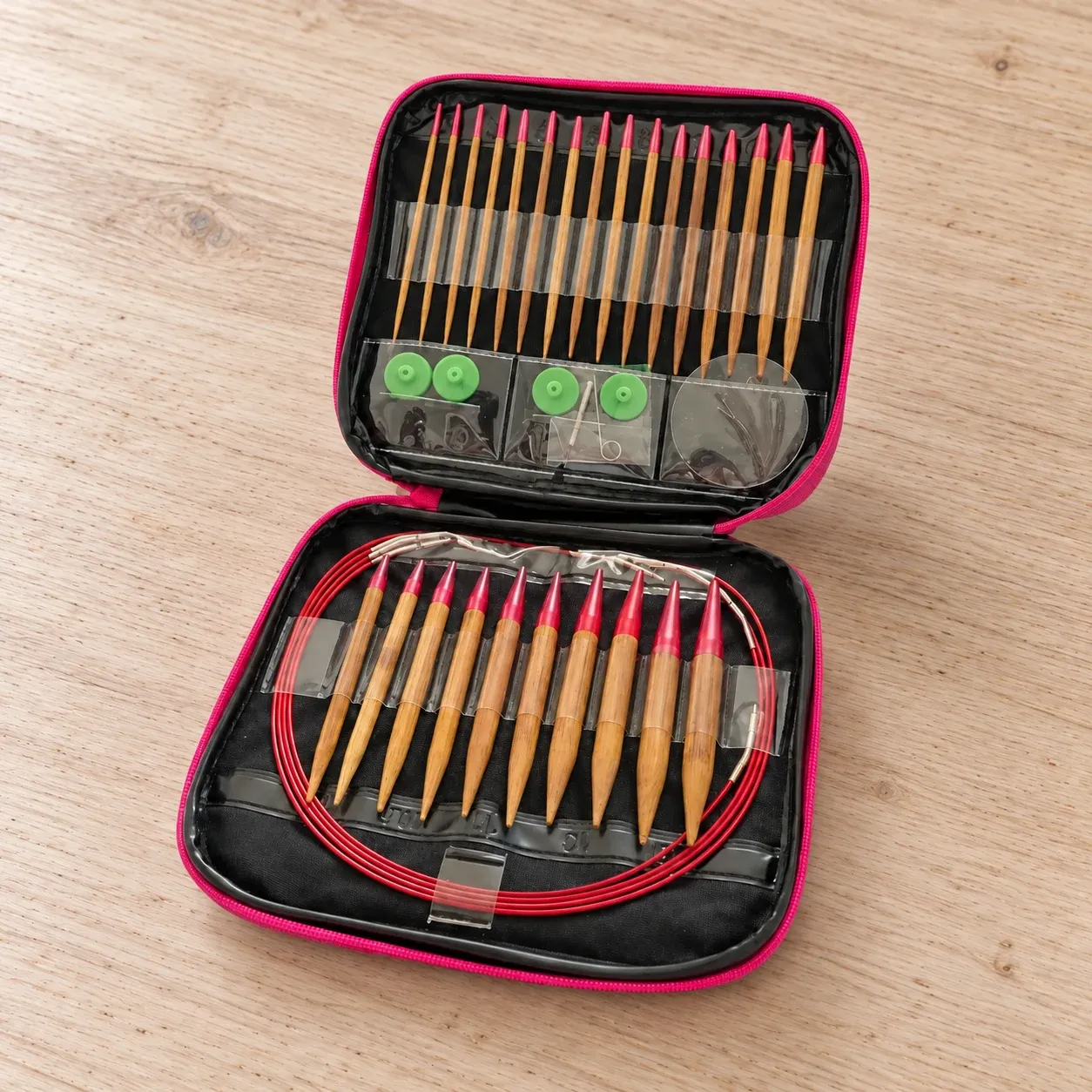 Open pink-trimmed case with thirteen pairs of bamboo needle tips