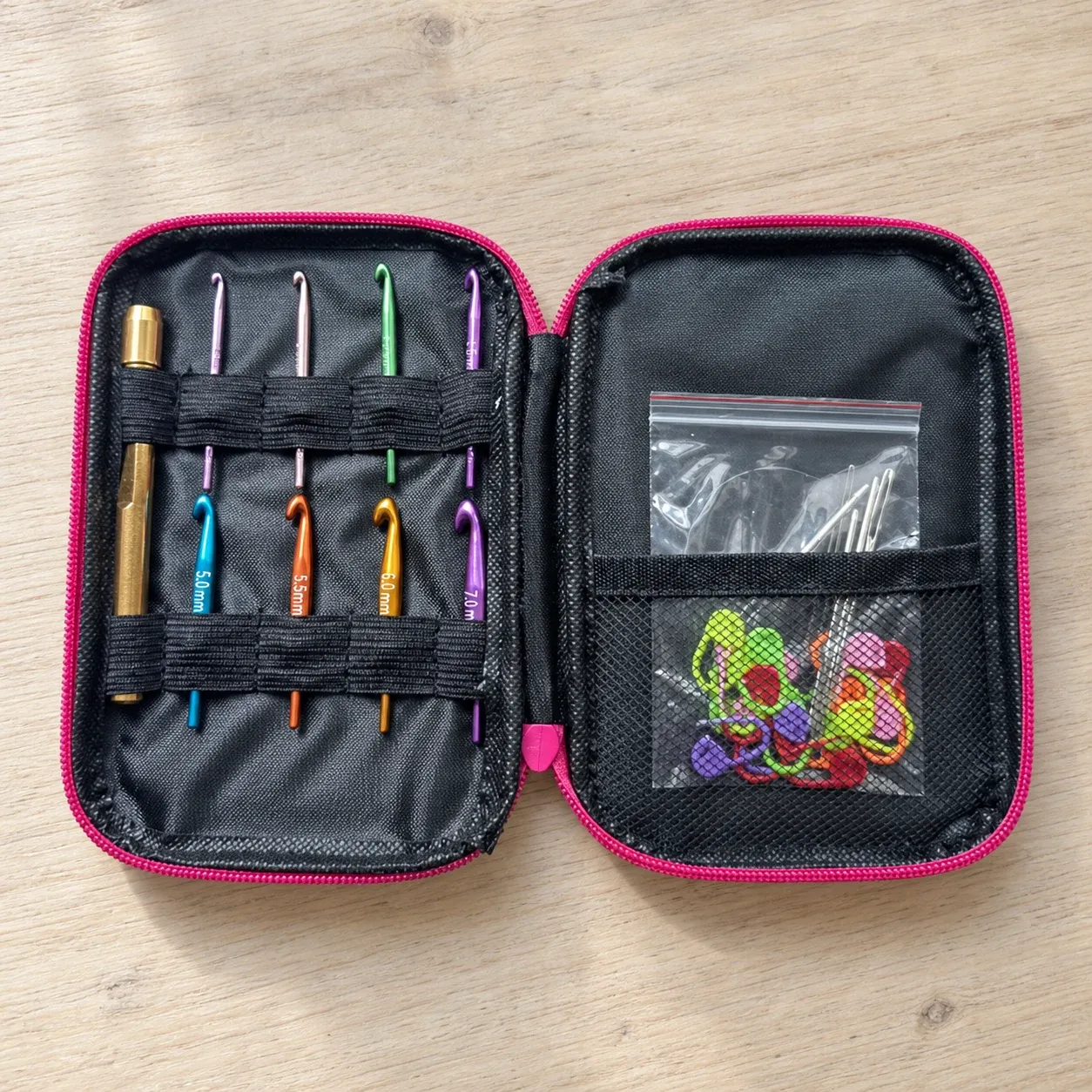 Open pink crochet case with eight hook heads, handle and accessories